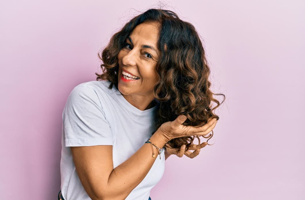 mulher-morena-de-blusa-branca-sobre-um-fundo-lilas-com-cabelo-ondulado-representando-as-curvaturas-2a-2b-2c